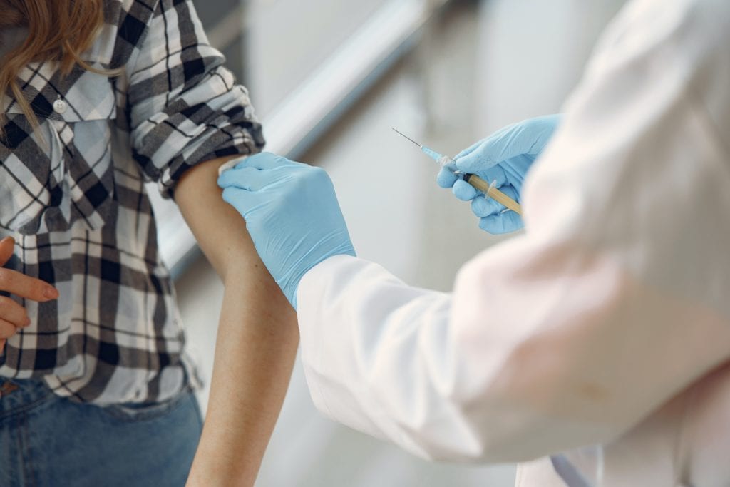 A woman receives a dose of the Covid-19 vaccine in her left arm. 